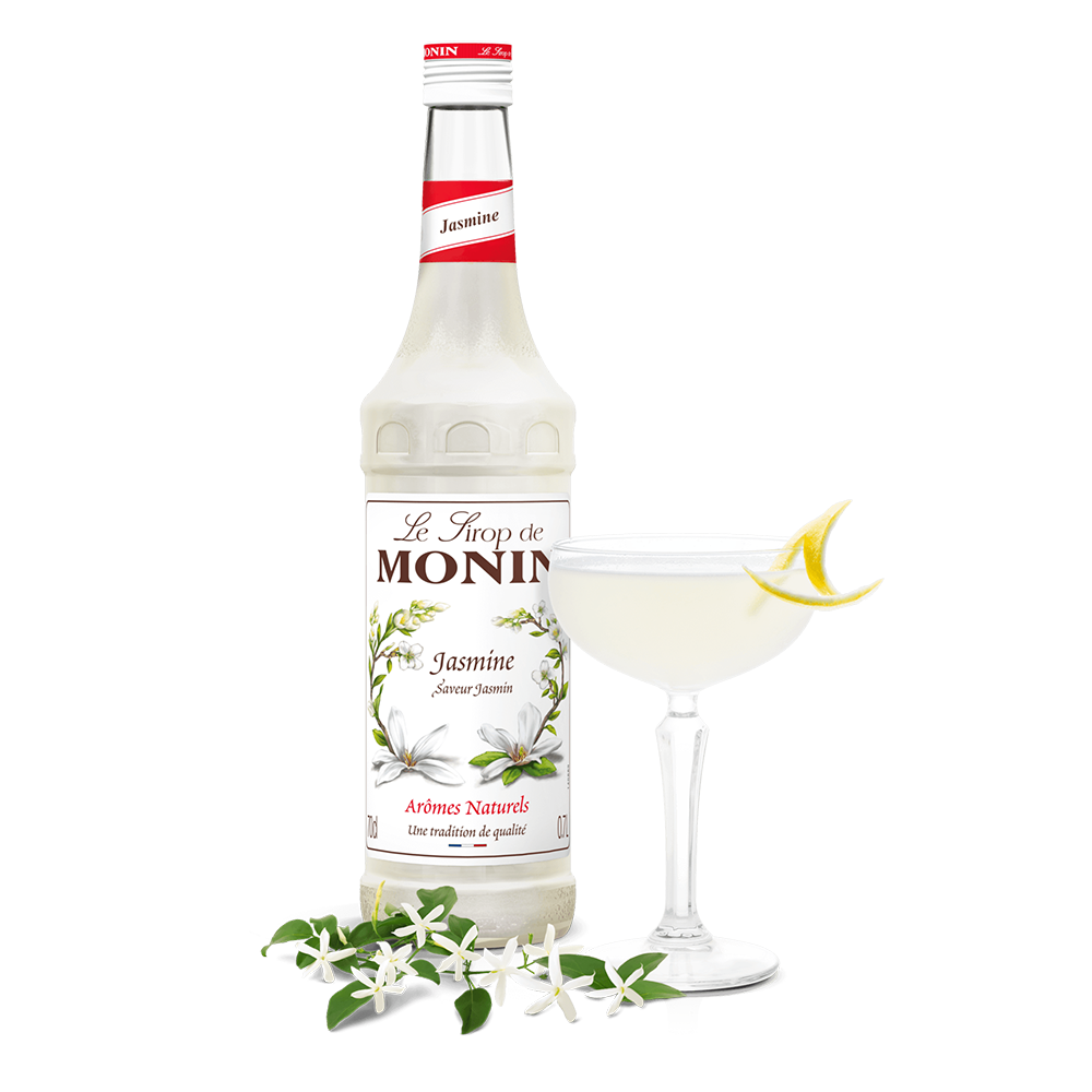 monin jasmine syrup bottle beside a cocktail glass