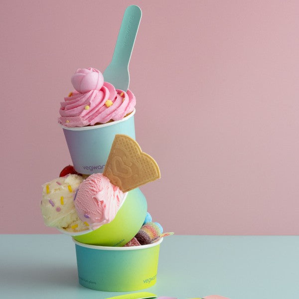 Stack of colorful ice cream in gradient cups with a pink background