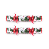 Two Christmas crackers with holly design on a white background
