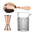 copper jigger along with copper julep strainer and astro mixing glass on a white background 