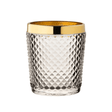 Clear glass tumbler with gold rim on a white background