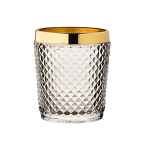 Clear glass tumbler with gold rim on a white background