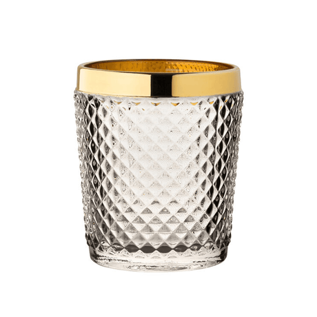 Clear glass tumbler with gold rim on a white background