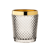 Clear glass tumbler with gold rim on a white background