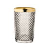 Clear textured glass tumbler with gold rim on a white background