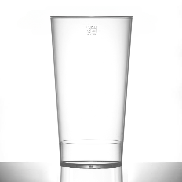 An empty clear polycarbonate drinking glass with a UKCA pint brim measurement marking.