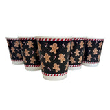 Set of four paper cups with gingerbread man design on a white background