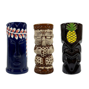 Three decorative tiki mugs with unique designs on a white background