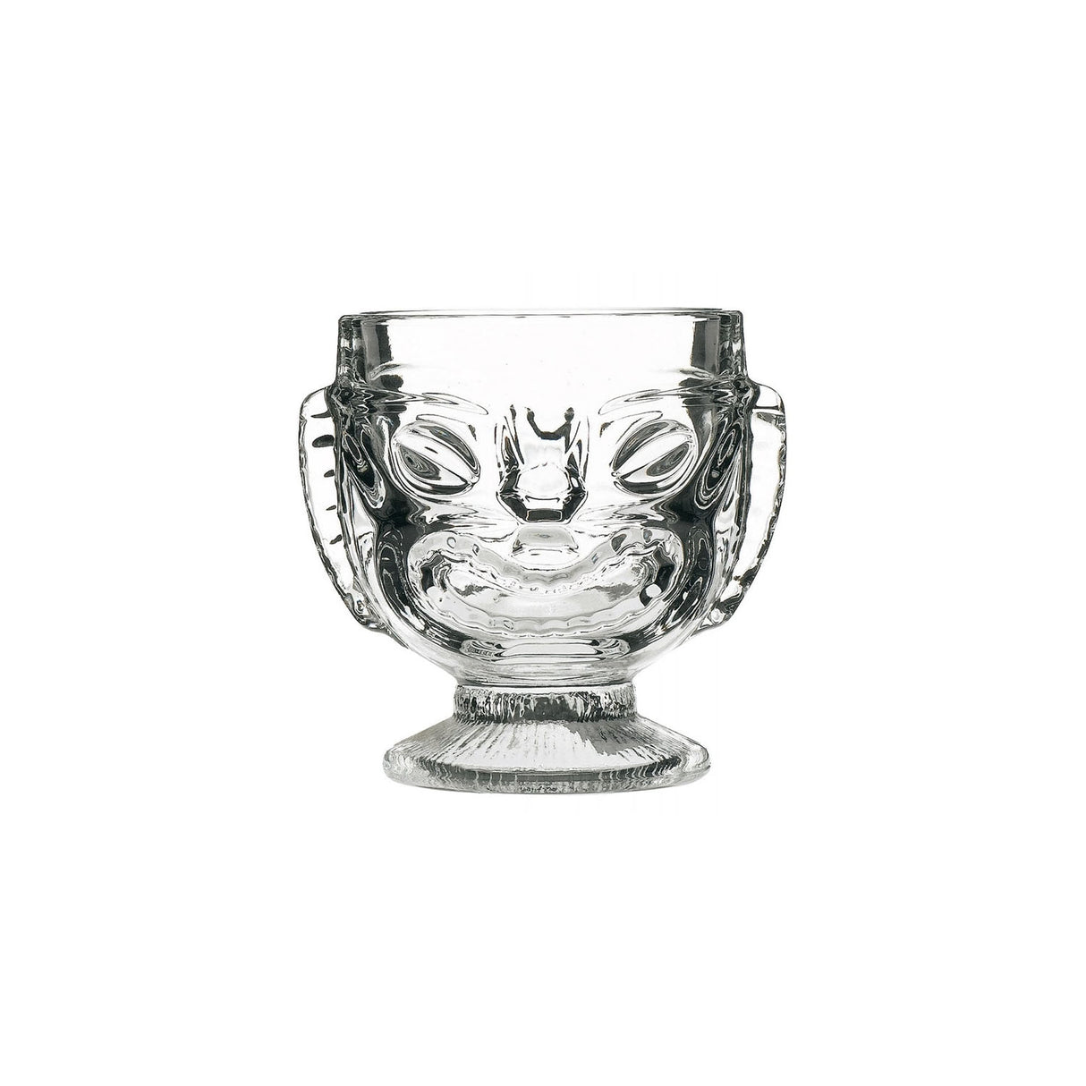 A clear glass with a Tiki-style head design, featuring a happy face on one side and a sad face on the reverse side, with a footed base.