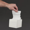 Hand picking a white napkin from a stack against a black background
