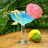 stemmed cocktail glass with blue drink and cockail umbrella