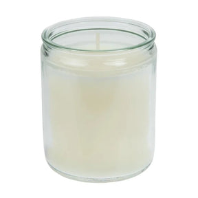 Clear glass candle jar with a white candle inside on a white background