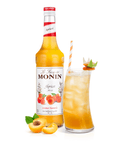 Monin apricot syrup bottle and cocktail in a long glass with straw