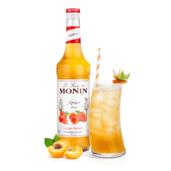 Monin apricot syrup bottle and cocktail in a long glass with straw