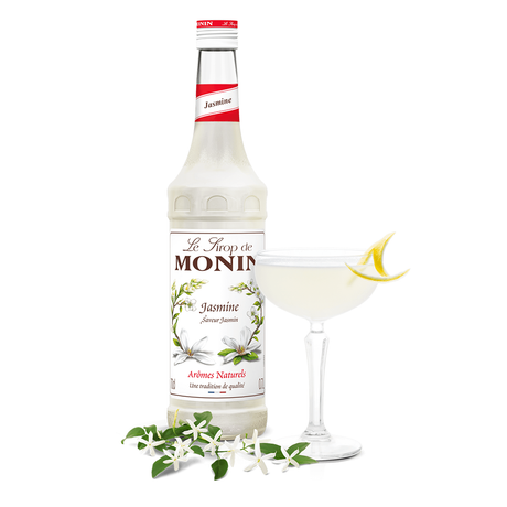 monin jasmine syrup bottle beside a cocktail glass 