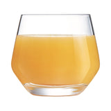 A clear glass filled with orange liquid, showcasing a contemporary angular shape with a thick base.