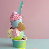 Stack of colorful ice cream in gradient cups with a pink background