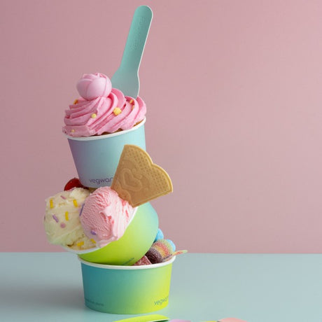 Stack of colorful ice cream in gradient cups with a pink background
