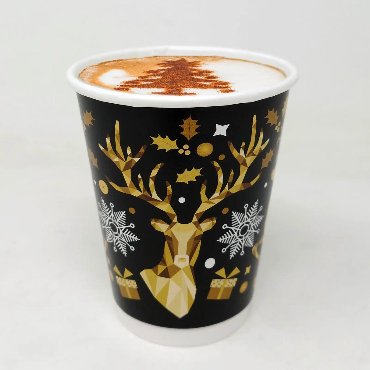 Black cup with gold deer design and white foam on a white background